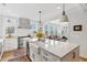 Open kitchen with white cabinets, a spacious island, and views into the living room at 2578 Helmsman Rd, Johns Island, SC 29455