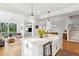 Open-concept living area with hardwood floors, white kitchen island, and access to an outdoor porch at 2578 Helmsman Rd, Johns Island, SC 29455