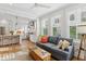 Cozy living room open to the kitchen, featuring hardwood floors, and natural light from the windows at 2578 Helmsman Rd, Johns Island, SC 29455