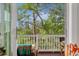 Relaxing porch with comfortable seating area and a view of lush greenery through an open screened in door at 2578 Helmsman Rd, Johns Island, SC 29455