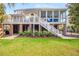 Expansive backyard showcasing a raised deck, screened porch, and lush greenery, perfect for outdoor living at 2645 Crooked Stick Ln, Mount Pleasant, SC 29466