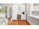 Elegant bar area with white cabinetry, wine fridge, marble countertops, and adjacent living space at 2645 Crooked Stick Ln, Mount Pleasant, SC 29466