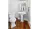 Chic powder room showcasing hardwood floors, classic pedestal sink, and modern fixtures for a sophisticated look at 2645 Crooked Stick Ln, Mount Pleasant, SC 29466