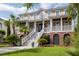 Stately two-story home featuring a grand staircase, covered porch, and lush, tropical landscaping at 2645 Crooked Stick Ln, Mount Pleasant, SC 29466