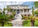 Stately two-story home featuring a grand staircase, covered porch, and lush, tropical landscaping at 2645 Crooked Stick Ln, Mount Pleasant, SC 29466