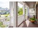 Inviting front porch featuring white columns, wood flooring, potted plants, and stylish lantern lighting at 2645 Crooked Stick Ln, Mount Pleasant, SC 29466