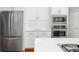 Stainless steel refrigerator and microwave nestled between clean white cabinets, and quartz countertop at 2645 Crooked Stick Ln, Mount Pleasant, SC 29466