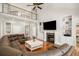 Bright living room featuring built-in shelving, a fireplace, a sectional sofa, and high ceilings with a ceiling fan at 2645 Crooked Stick Ln, Mount Pleasant, SC 29466