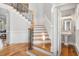 Elegant staircase with hardwood steps, iron railings, and wainscoting detailing, leading to an open floor plan at 2645 Crooked Stick Ln, Mount Pleasant, SC 29466