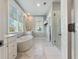 Bright, modern bathroom with a freestanding tub, glass shower, and ample natural light from windows at 2924 Tranquility Rd, Mount Pleasant, SC 29466