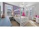 Bright bedroom with a loft bed, a lavender accent wall, and playful decor, creating a cheerful atmosphere at 2924 Tranquility Rd, Mount Pleasant, SC 29466