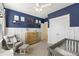 Comfortable Bedroom with blue accent wall, a glider chair, and a dresser, designed for relaxation and functionality at 2924 Tranquility Rd, Mount Pleasant, SC 29466