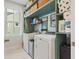 Bright laundry room features modern machines, practical shelving, and a sunlit window at 2924 Tranquility Rd, Mount Pleasant, SC 29466