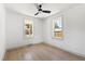 Bright, empty bedroom with hardwood floors, modern ceiling fan and two large windows with natural light at 2957 Alabama Dr, North Charleston, SC 29405