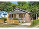 Quaint brick home featuring a covered porch with wooden columns and a modern horizontal-plank fence at 2957 Alabama Dr, North Charleston, SC 29405