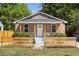 Charming brick home featuring a well-manicured lawn, a stylish wood fence, and a welcoming front porch at 2957 Alabama Dr, North Charleston, SC 29405