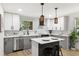 Bright kitchen with white and gray cabinets, island, stainless steel appliances and modern lighting at 2957 Alabama Dr, North Charleston, SC 29405