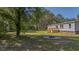 Wide shot of the backyard with a fire pit, lush trees, and a peek at the house at 314 Hickory Nut Way, Cross, SC 29436