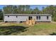 Low angle view of a home with gray siding and a wood deck in a grassy backyard at 314 Hickory Nut Way, Cross, SC 29436