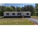 Inviting single-story home with gray siding and black shutters, complemented by a well-kept lawn and gravel driveway at 314 Hickory Nut Way, Cross, SC 29436