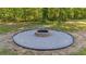 Backyard with a gravel fire pit with retaining wall surrounded by green space at 314 Hickory Nut Way, Cross, SC 29436