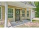 Welcoming front entrance with black door, decorative wreath, and 'HOME' sign, framed by white columns and green windows at 333 Price St, Goose Creek, SC 29445