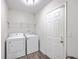 Efficient laundry room with white appliances, overhead shelving, and wood-look flooring at 333 Price St, Goose Creek, SC 29445