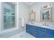 Bathroom features double sinks with blue vanity, wicker framed mirrors, and modern fixtures at 3635 Pandora Dr, Mount Pleasant, SC 29466