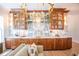 Detailed view of the custom bar with marble backsplash, wooden cabinets, and gold lighting fixtures at 3688 Goodwater St, Mount Pleasant, SC 29466