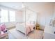 Bright bedroom with a canopy bed, pink accents, and hardwood floors with an area rug at 3688 Goodwater St, Mount Pleasant, SC 29466