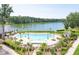 Aerial view of a community pool with palm trees and lounge chairs next to a scenic lake at 3688 Goodwater St, Mount Pleasant, SC 29466
