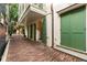 Exterior shot featuring a brick-paved walkway, balcony, with shutters and an arched entry, exuding classic elegance at 4 Catfiddle St, Charleston, SC 29403