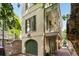 Charming home exterior with green shutters, covered balcony, and brick paved walkway with arched garage at 4 Catfiddle St, Charleston, SC 29403