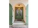 Inviting arched doorway with glass-paned door, stone steps, and exterior lantern at 4 Catfiddle St, Charleston, SC 29403