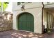 Stylish home featuring a brick driveway and unique green carriage-house garage door at 4 Catfiddle St, Charleston, SC 29403