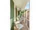 Charming porch with two white chairs, a white railing, and view of greenery and neighborhood at 4 Catfiddle St, Charleston, SC 29403