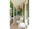 Inviting porch with white furniture, green shutters, and views of the surrounding greenery at 4 Catfiddle St, Charleston, SC 29403