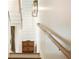 Stylish staircase with wooden rail and a modern light fixture, complemented by a small, elegant chest on the landing at 4 Catfiddle St, Charleston, SC 29403