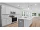 Modern kitchen boasts white cabinetry, stainless steel appliances, and an island with a sink at 403 Cadbury Loop, Summerville, SC 29486
