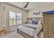 Cozy bedroom featuring a queen-sized bed, wood furnishings, neutral decor, and natural light from the window at 404 Snowy Plover Ln, Summerville, SC 29486