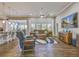 Open-concept living room features hardwood floors, comfortable seating, a ceiling fan, and a mounted TV at 404 Snowy Plover Ln, Summerville, SC 29486