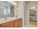 Bathroom with double sinks, wooden cabinets, and a door to a walk-in closet at 405 Decatur Dr, Summerville, SC 29486