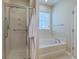 Bright bathroom featuring a glass enclosed shower and separate soaking tub with a window at 405 Decatur Dr, Summerville, SC 29486