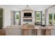 Open-concept living room boasts fireplace with TV above and natural light from the two windows at 406 Cadbury Loop, Summerville, SC 29486