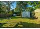 Spacious backyard featuring well-maintained lawn, a wooden fence, and storage sheds for tools and equipment at 4515 Holmes Ave, North Charleston, SC 29405