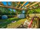 Backyard patio area featuring a wooden pergola, a small storage shed and a comfortable rocking chair at 4515 Holmes Ave, North Charleston, SC 29405