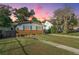 Charming single-story home with a brick foundation, blue shutters, and lush green lawn at dusk at 4515 Holmes Ave, North Charleston, SC 29405