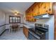 Well-lit kitchen with wooden cabinets, black appliances, and a cozy dining area at 4515 Holmes Ave, North Charleston, SC 29405