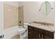 Bathroom with a bathtub, dark vanity, tiled walls, and a round mirror at 4637 Bonnie Marie Way, North Charleston, SC 29405