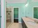 Well-lit bathroom with double sinks, a glass shower, stone counters, and a walk-in closet at 4637 Bonnie Marie Way, North Charleston, SC 29405